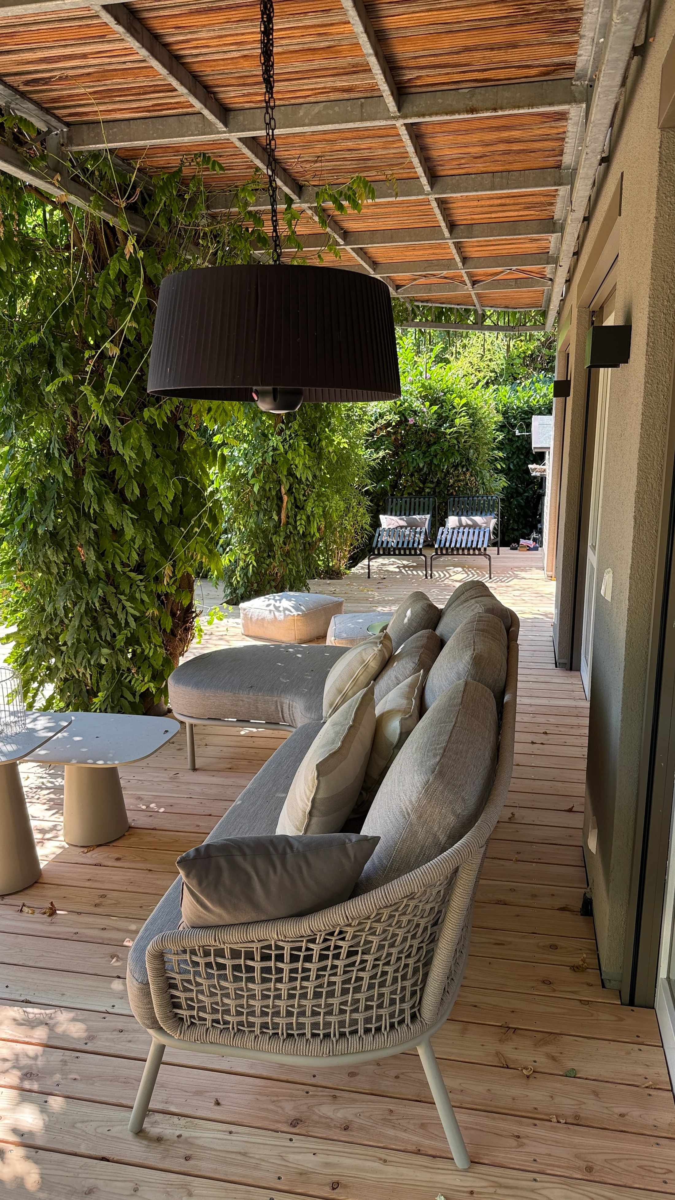 Überdachte Holzterrasse mit bepflanztem Sitzbereich